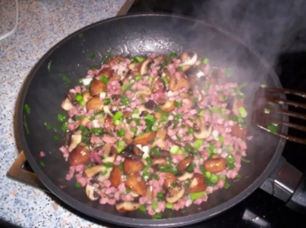 Острые блины с коричневыми грибами и зеленым луком