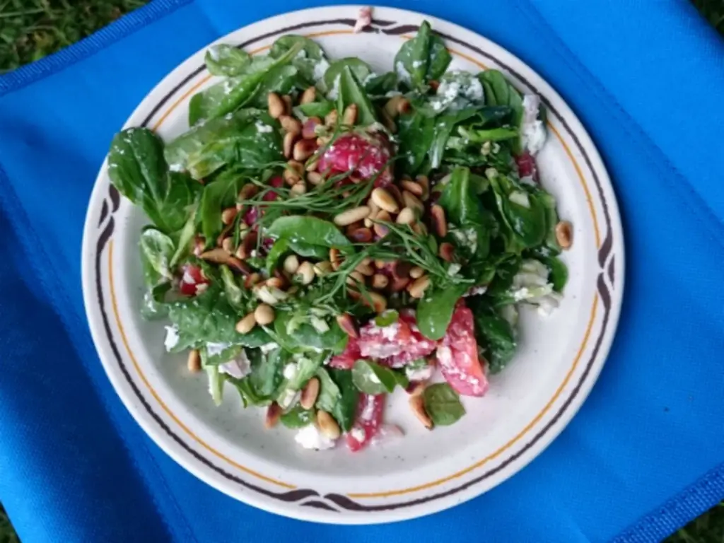 Салат из ягнят с помидорами черри, малиной, фетой и жареными кедровыми орешками