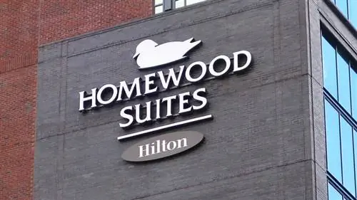 Вывеска хоумвуд люкс на красно-серой стене