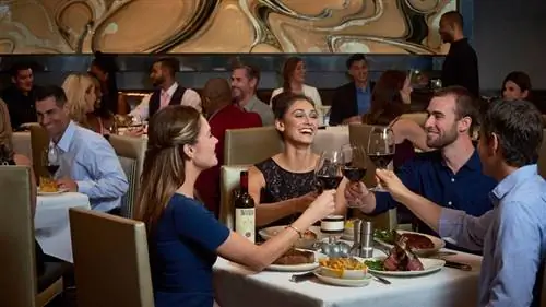 Улыбающиеся люди обедают за столами