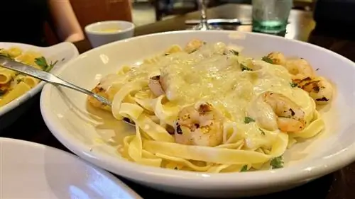 жареные креветки с оливковым садом и паста альфредо в миске