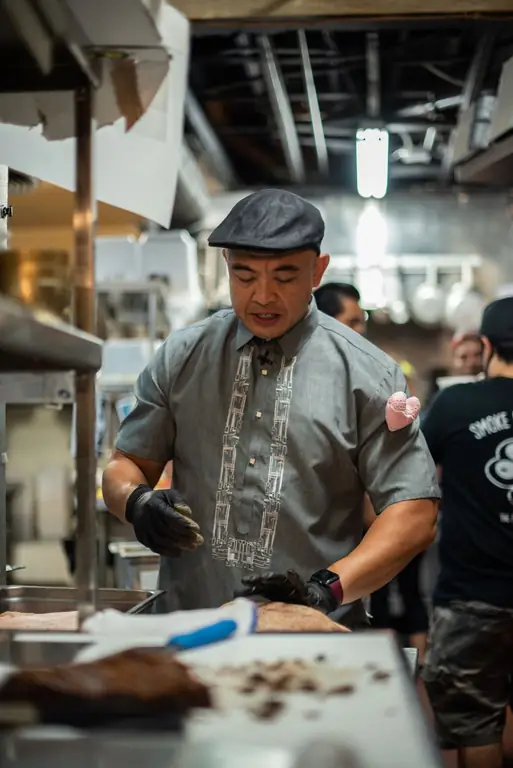 Johneric Concordia приправляет мясо на кухне Park’s Finest Barbecue