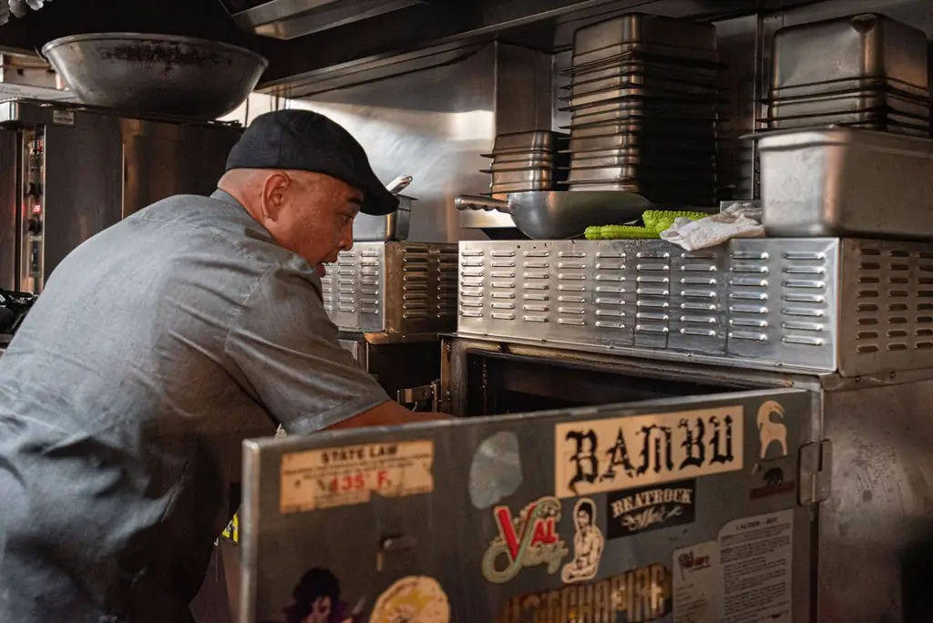 Джонерик Конкордия проверяет мясо внутри коптильни в ресторане Park’s Finest