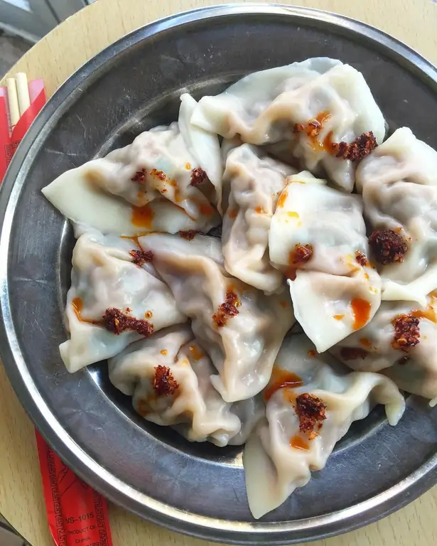 Вареные пельмени, покрытые маслом чили