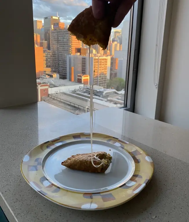 Зеленые блинчики с бананами разбирают, чтобы показать белый сыр внутри