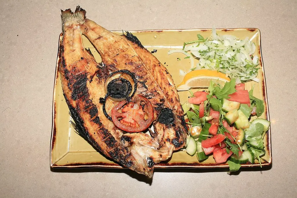 Masgouf в Al Enam, подается вместе с двумя салатами с долькой лимона