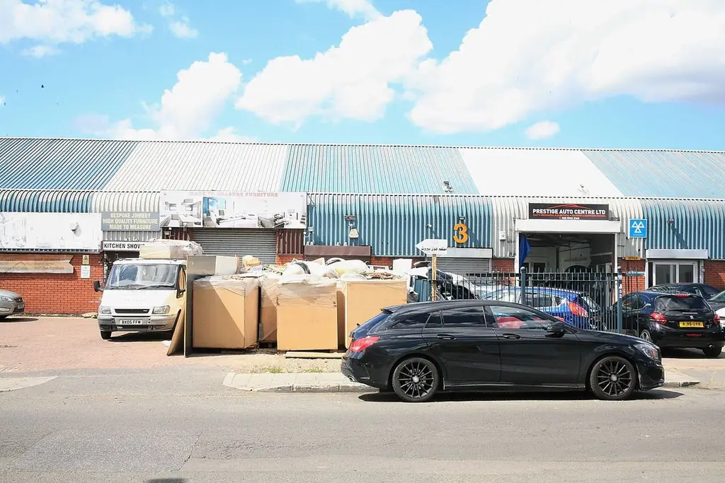 Черный Porsche Cayenne перед бизнес-центром Park Royal’s Acton и забором