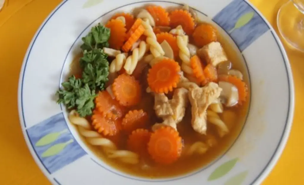 Рагу с филе куриной грудки, цветками моркови, луком, грибами и лапшой