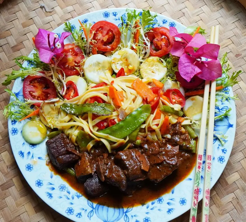 Экзотический гуляш из козьего мяса с разноцветной лапшой и салатом