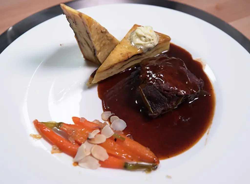 Тушеные телячьи щечки в соусе из красного вина с картофельным пирогом и медовой морковью