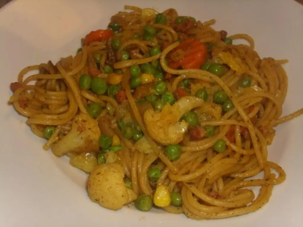 Жареная лапша с нарезанной кубиками ветчиной и савойской капустой